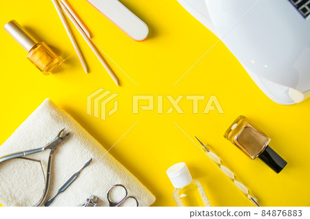 Set of tools for manicure and nail care on a yellow background. Place for text. 84876883