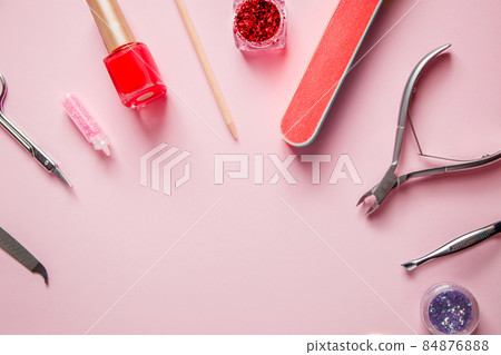 A set of tools for manicure and nail care on a pink background. Workplace in a beauty salon. Place for text. A set of tools for manicure and nail care on a pink background. Workplace in a beauty salon. Place for text. 84876888