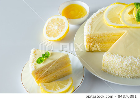 Lemon cake with coconut flakes. A piece of delicate vanilla dessert with cream. Lemon cake with coconut flakes. A piece of delicate vanilla dessert with cream. 84876891