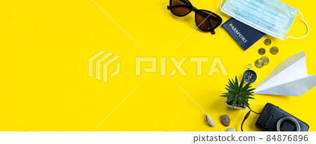 Travel planning during the coronavirus pandemic. Passport, notepad and medical mask on a blue background. New normal. Banner format Travel planning during the coronavirus pandemic. Passport, notepad and medical mask on a blue background. New normal. Banner format 84876896