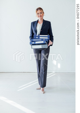 woman 40 years old with folders for papers in a white office woman 40 years old with folders for papers in a white office 84877295