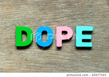 Color alphabet letter in word dope on wood background Color alphabet letter in word dope on wood background 84877483
