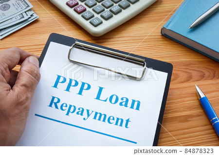 A man holds PPP loan repayment application. 84878323