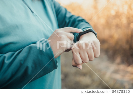Active sport woman setting up the fitness smart watch for timing running workout. Active sport woman setting up the fitness smart watch for timing running workout. 84878330
