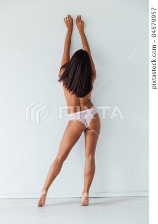 beautiful tanned woman in lingerie in a white room 84879957