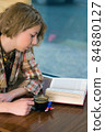 Girl reading in coffee shop 84880127
