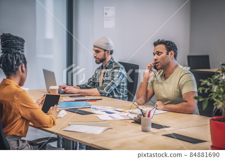 Two guys and girl sitting at common table Two guys and girl sitting at common table 84881690