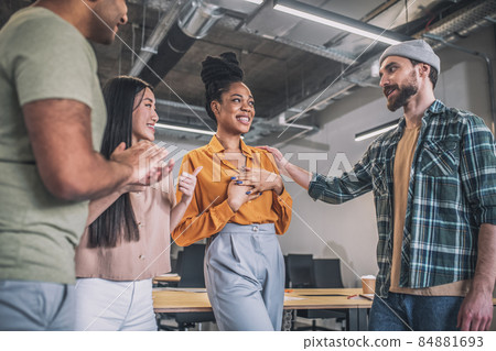 Smiling guys and girls happily communicating in office Smiling guys and girls happily communicating in office 84881693