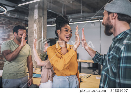 Smiling guys and girls gesturing friendly in office Smiling guys and girls gesturing friendly in office 84881697