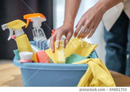Close up picture of hands taling something from the box with cleaning supplies Close up picture of hands taling something from the box with cleaning supplies 84881703