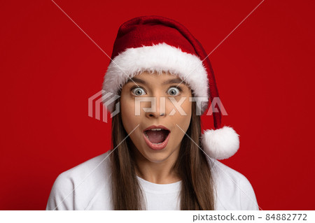 Amazing Offer. Portrait Of Shocked Woman Wearing Santa Hat Looking At Camera 84882772