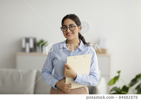 Portrait of happy middle eastern female psychologist smiling at camera during therapy session, working in clinic Portrait of happy middle eastern female psychologist smiling at camera during therapy session, working in clinic 84882878