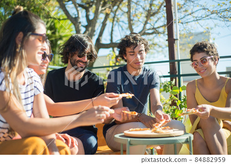 Peaceful male and female friends sitting at table at party Peaceful male and female friends sitting at table at party 84882959