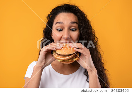 Funny Latin Lady Holding Burger Biting Sandwich At Studio 84883493