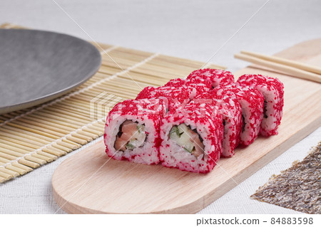 a portion of rolls on a stand, japanese food, sushi on the table, chinese chopsticks, light background 84883598