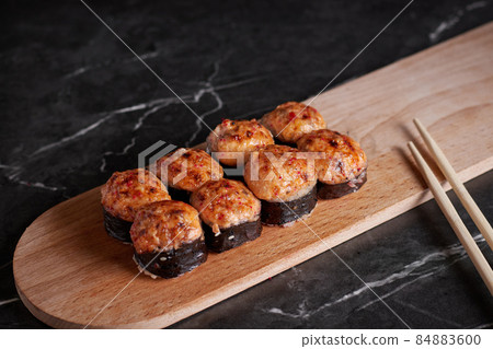 a portion of rolls on a stand, japanese food, sushi on the table, chinese chopsticks, dark background a portion of rolls on a stand, japanese food, sushi on the table, chinese chopsticks, dark background 84883600
