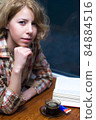 Girl drinking coffee and reading a book 84884516