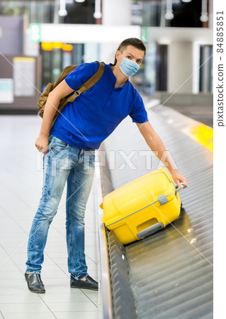 Young man in an airport lounge waiting for flight aircraft. 84885851