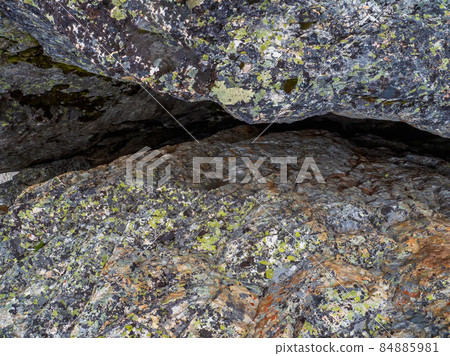 Crack in granite. Narrow entrance to the cave. Fault line or fracture in the rock, erosion, a crack in the stone. 84885981