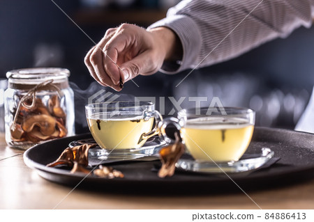 Detail of a bartender's hand flavoring Hot Teddy whiskey drink with cloves 84886413