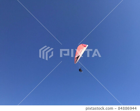 Skydiver is flying with parachute in blue sky Skydiver is flying with parachute in blue sky 84886944