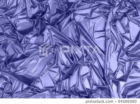 Shiny crumpled foil surface for textured background. Backdrop for your design. Toned in trendy color of year 2022. Copy space. 84886980
