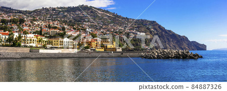 Madeira island. View of Funchal town from sea side for fortress Sao Tiago and city beach. Portugal travel and landmarks Madeira island. View of Funchal town from sea side for fortress Sao Tiago and city beach. Portugal travel and landmarks 84887326