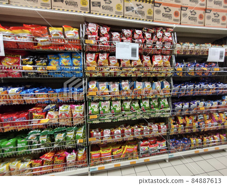 JOHOR, MALAYSIA -APRIL 18, 2021: Selective focused on packed miscellaneous brand junk foods and snacks on the rack and display for sale in the supermarket. Each has its own price tag.  84887613
