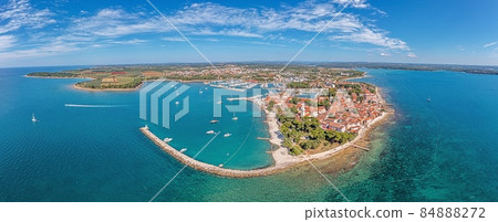 Drone panorama over the Croatian coastal town Novigrad with harbor and promenade taken from the sea side during the day 84888272