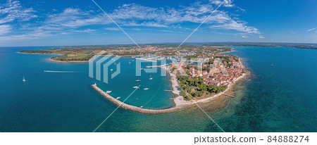 Drone panorama over the Croatian coastal town Novigrad with harbor and promenade taken from the sea side during the day 84888274