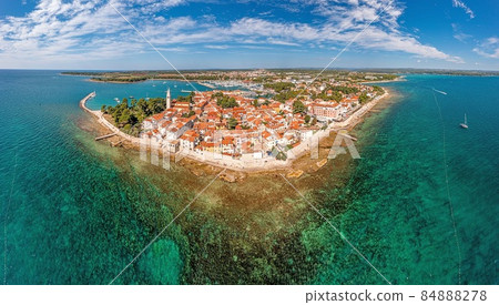 Drone panorama over the Croatian coastal town Novigrad with harbor and promenade taken from the sea side during the day 84888278