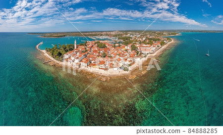 Drone panorama over the Croatian coastal town Novigrad with harbor and promenade taken from the sea side during the day 84888285