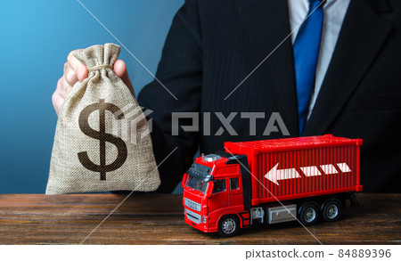 Businessman with dollar money bag and truck. High income of the transport business and the transport of goods. Good salaries for drivers. Rising prices, global containers shortage crisis. Logistics Businessman with dollar money bag and truck. High income of the transport business and the transport of goods. Good salaries for drivers. Rising prices, global containers shortage crisis. Logistics 84889396