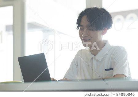A young man watching a computer A young man watching a computer 84890846