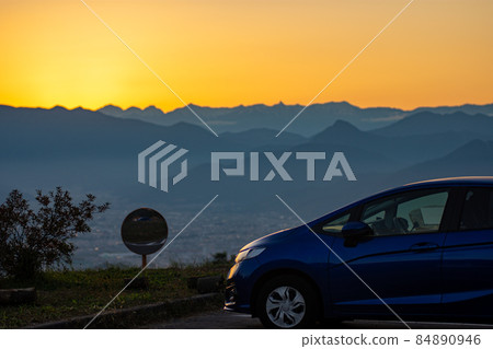 Mountain range and car seen from the mountainside at dusk in autumn 84890946