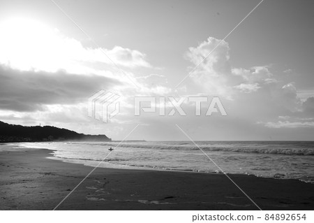 One surfer entering the sea at sunrise 84892654