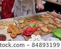 Happy Asian little girl cooking gingerbread at home with parent for Christmas day. Homemade Xmas cookies for kid. 84893199