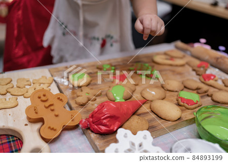 Happy Asian little girl cooking gingerbread at home with parent for Christmas day. Homemade Xmas cookies for kid. Happy Asian little girl cooking gingerbread at home with parent for Christmas day. Homemade Xmas cookies for kid. 84893199
