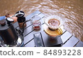 Man dripping hot coffee and camping near river at nature park. Outdoor activity and relax on holiday. 84893228