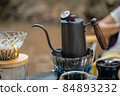 Man dripping hot coffee and camping near river at nature park. Outdoor activity and relax on holiday. 84893232