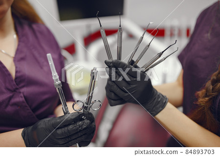 Dental tools in a dentist hand Dental tools in a dentist hand 84893703