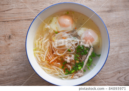 Soup bowl, soup noodle pork white noodle with vietnamese pork soft boiled eggs and bean sprout vegetable spring onion in soup bowl on wooden table, Thai Asian food 84893971