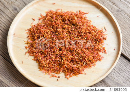 Dried safflower for herbal tea on tray wooden background, dry safflower petals, Saffron substitute 84893993