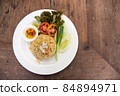 Fried rice with crab, tomato, cucumber, spring onion, and fish sauce on wood table 84894971