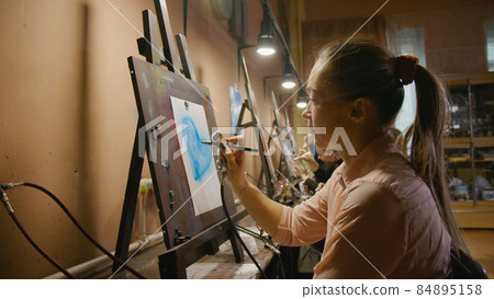 Woman artist learns to paint with airbrush with acrylic dye, paper and easel. Concept modern art, airbrushing, aerography, graffiti, aerosol spray 84895158
