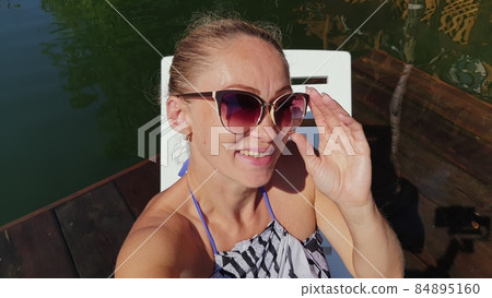 Woman shooting self portrait. Take photo and video on smartphone. Girl rest, relax, walk in sunglasses, make selfie. Blogger broadcast video vlogging. 84895160