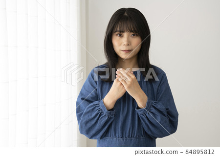 A young woman wearing a wedding ring on her left ring finger A young woman wearing a wedding ring on her left ring finger 84895812