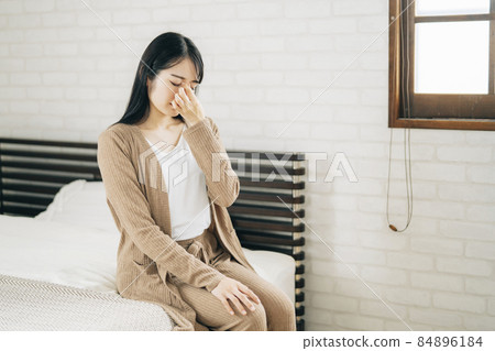 Japanese woman suffering from eye strain, dry eye, tired eyes in the bedroom Japanese woman suffering from eye strain, dry eye, tired eyes in the bedroom 84896184