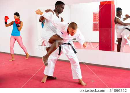 Two men exrcising self defence moves and woman boxing 84896232