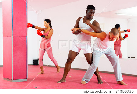 Two men exrcising self defence moves and woman boxing 84896336